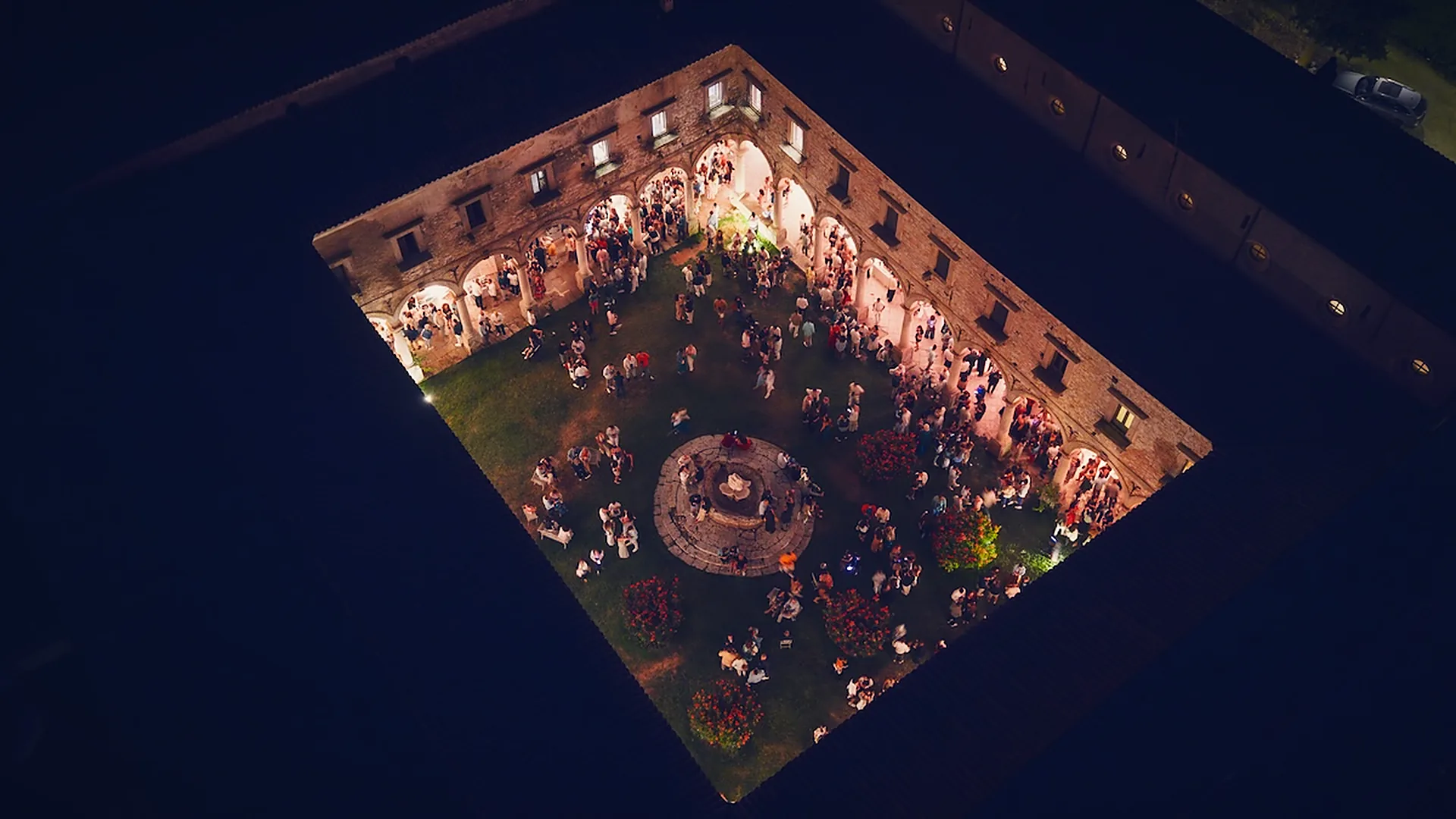 Il chiostro di notte visto dal drone, pieno di gente durante un evento